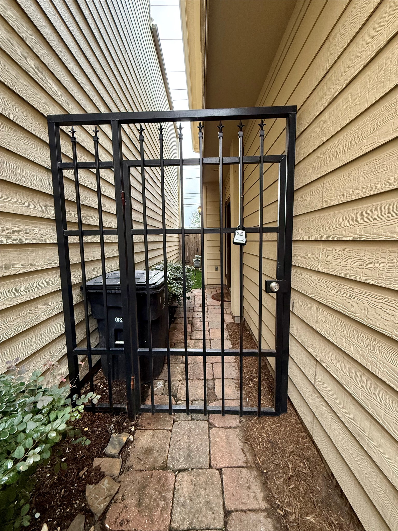 3540 Cline Street Houston, TX 77020 - Photo 22 of 26 Private side-yard entrance with a secure iron gate and paved walkway.