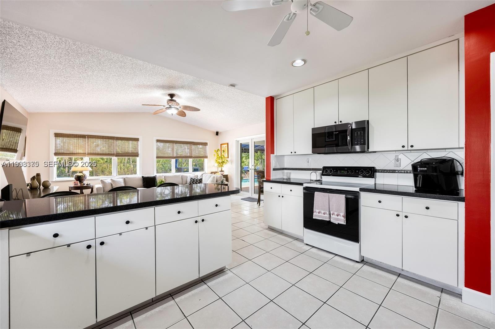 8610 Southwest 83rd Street Miami, FL 33143 - Photo 16 of 45 a kitchen with granite countertop a sink stainless steel appliances and cabinets