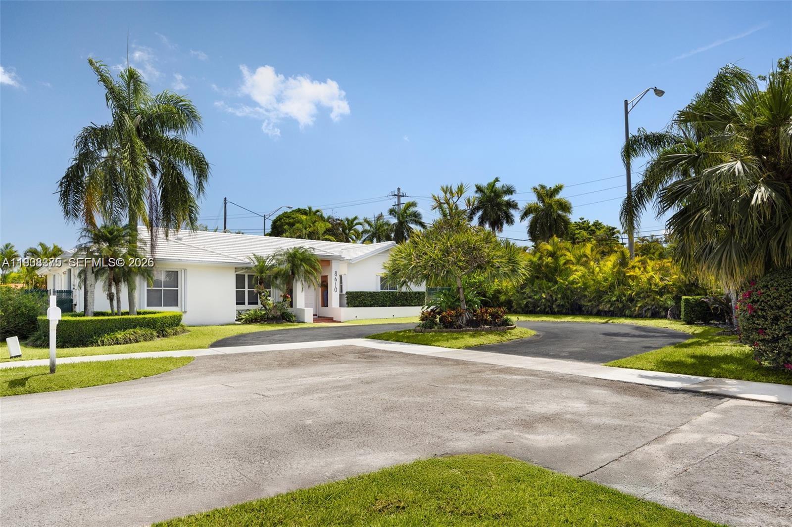 8610 Southwest 83rd Street Miami, FL 33143 - Photo 2 of 45 a front view of a house with a yard and palm trees