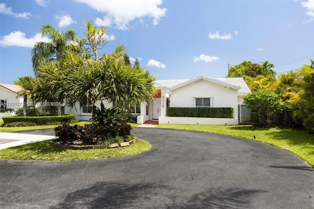 a front view of a house with a yard and a garden