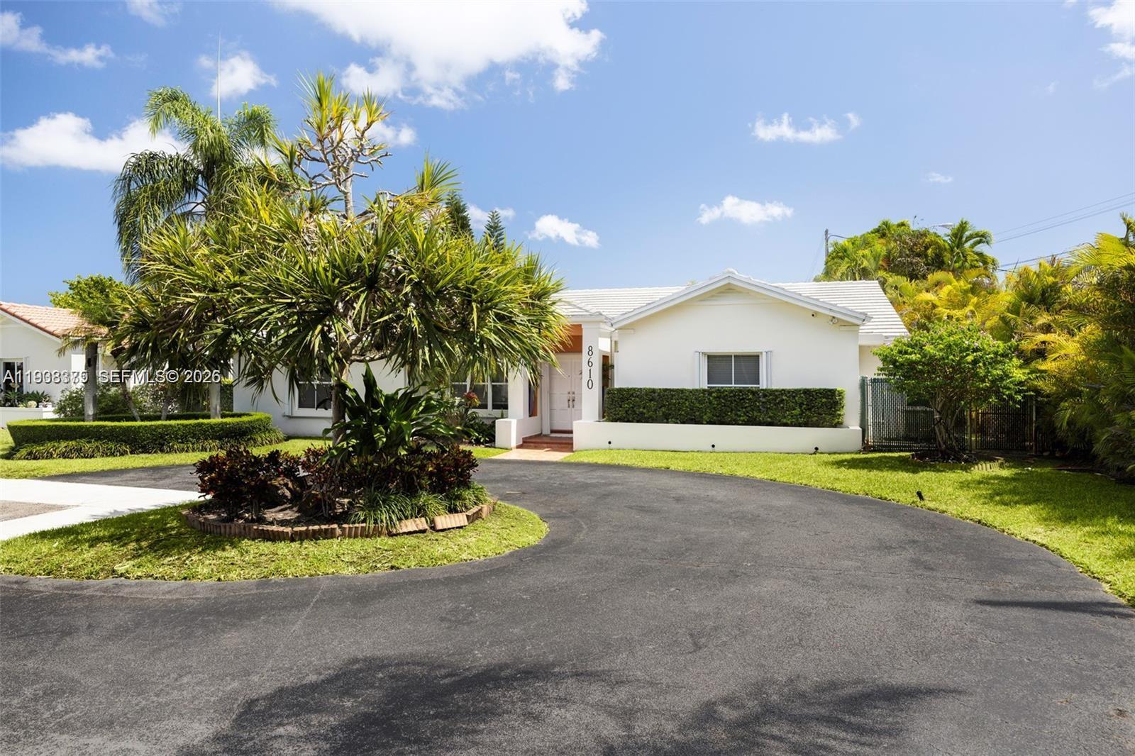 8610 Southwest 83rd Street Miami, FL 33143 - Photo 3 of 45 a front view of a house with a yard and a garden