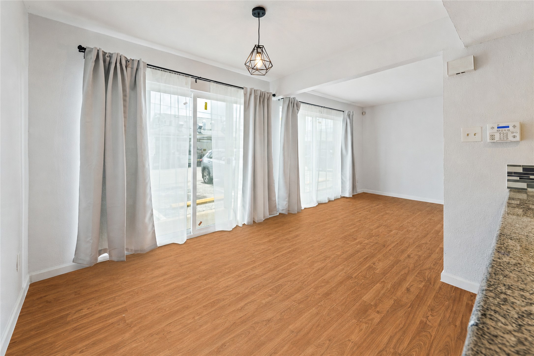 2124 Burton Drive, Unit 159 Austin, TX 78741 - Photo 7 of 23 Laminated flooring stretches through this open space, illuminated by expansive sliding glass doors.