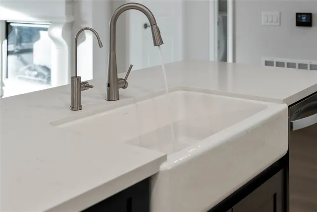 a close view of kitchen with chandelier and livingroom