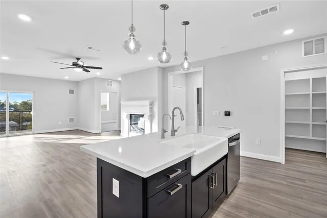 a kitchen with a sink a stove cabinets and wooden floor