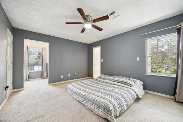 a bedroom with a large bed chandelier and window