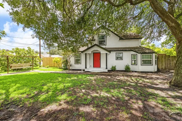a view of a house with backyard and tree