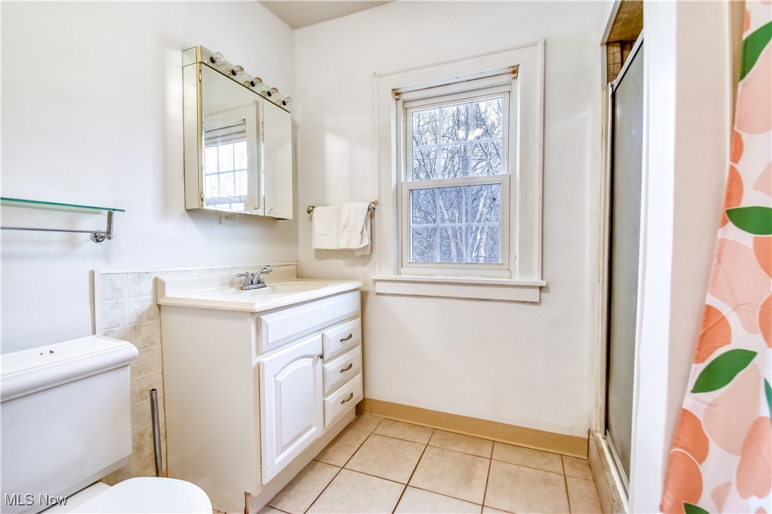 3733 East Antisdale Road Cleveland, OH 44118 - Photo 14 of 28 Bathroom featuring vanity, toilet, baseboards, tile patterned floors, and an enclosed shower