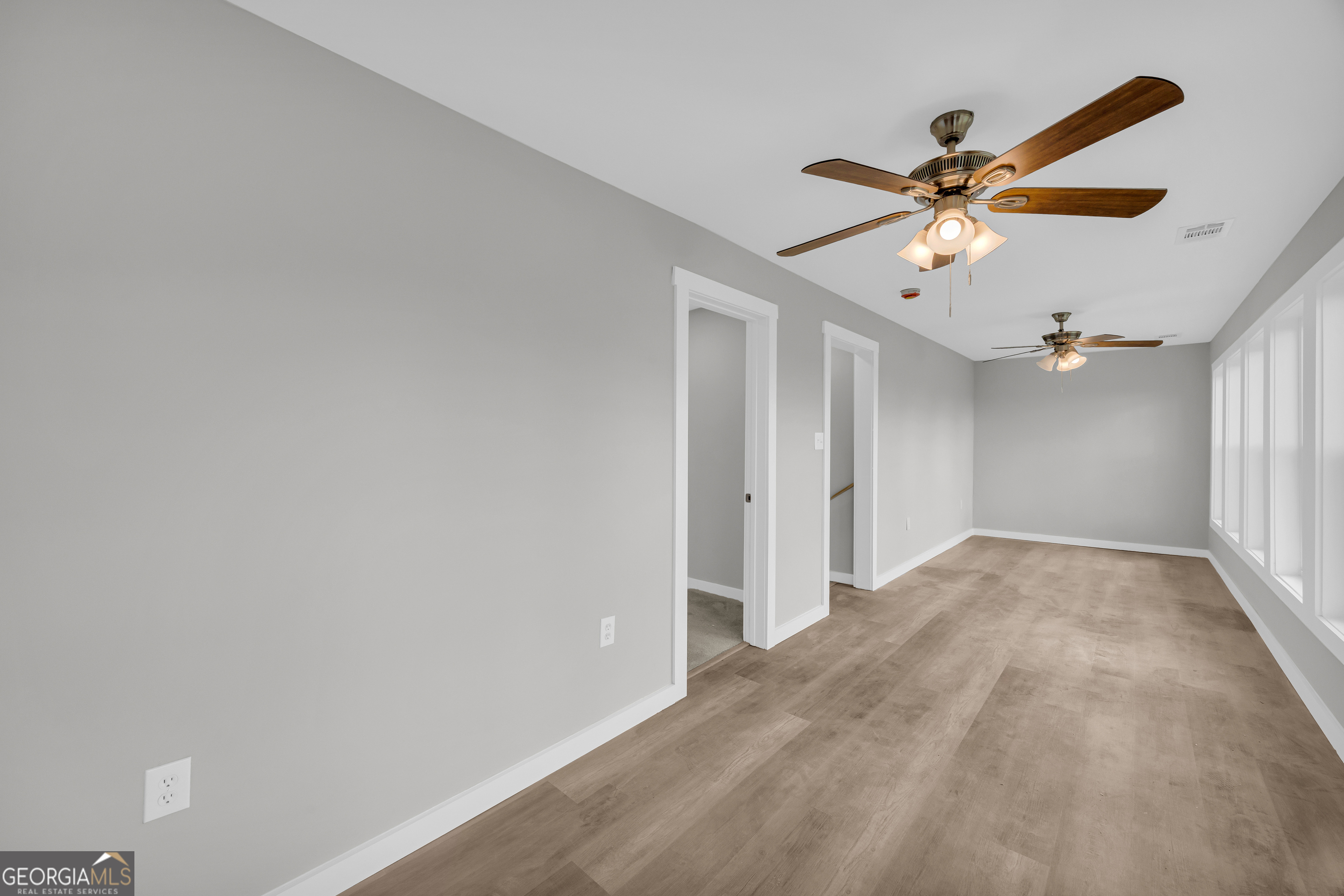 8606 Holly Springs Road Maysville, GA 30558 - Photo 55 of 74 a view of a big room with a ceiling fan and a chandelier fan
