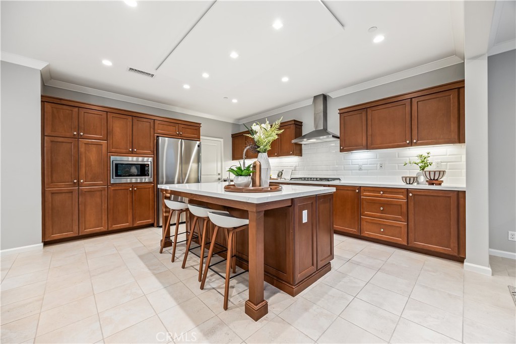 51 Decker Irvine, CA 92620 - Photo 5 of 49 a kitchen with stainless steel appliances kitchen island granite countertop a stove refrigerator and cabinets