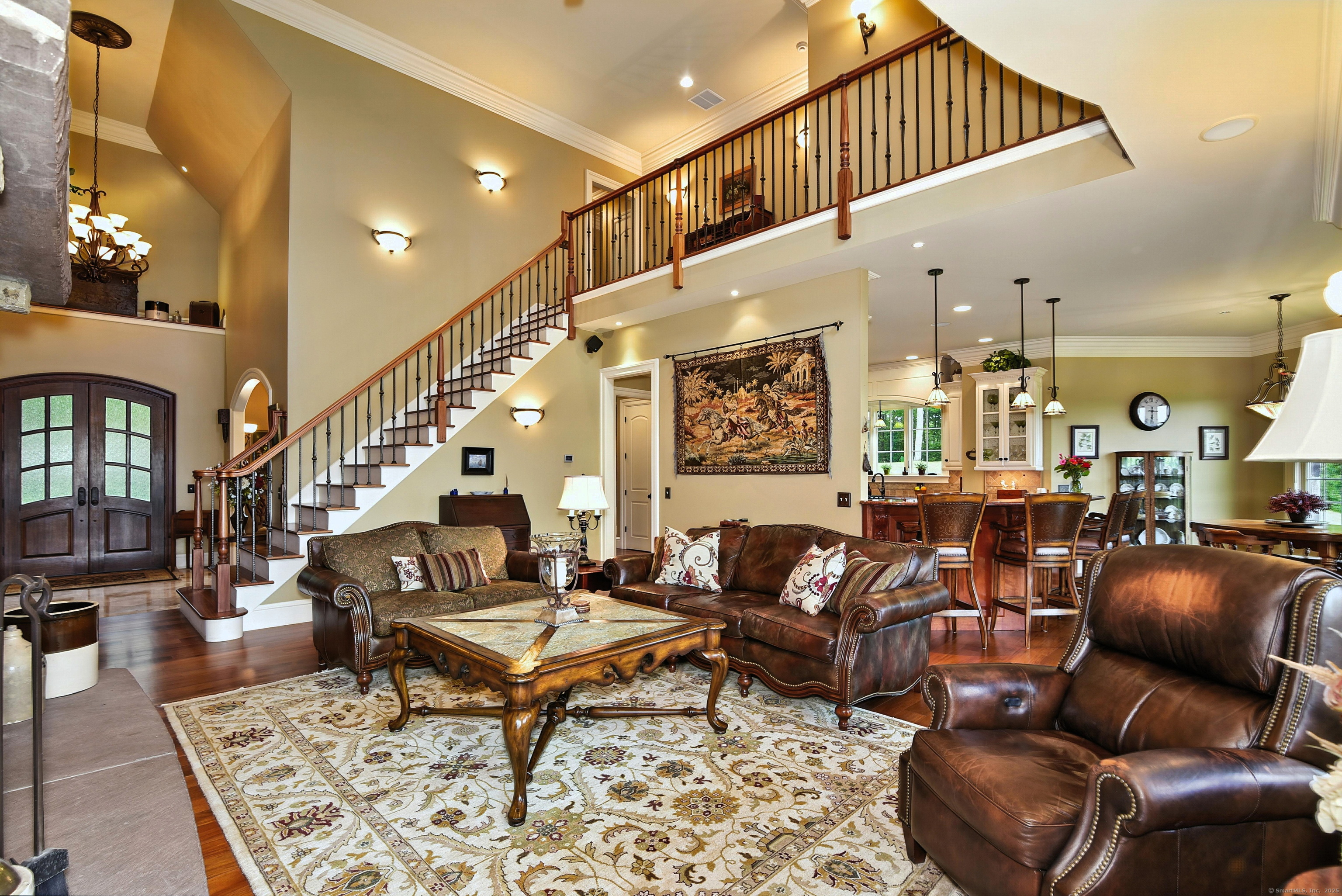 282 Searles Road Pomfret, CT 06259 - Photo 27 of 40 Spectacular details in the great room: The mahogany staircase with iron balusters, solid mahogany arched, double-door entry, and exquisite lighting.