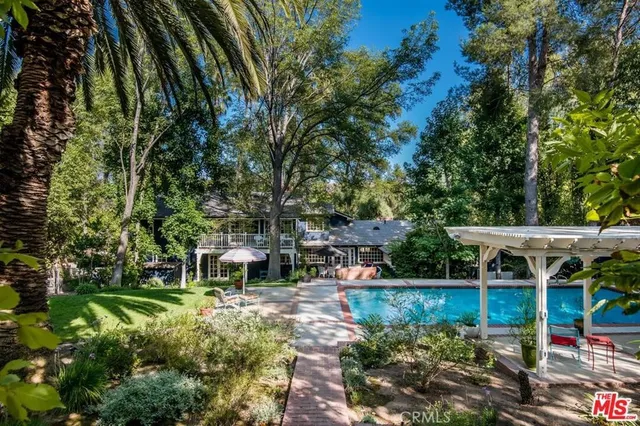 a view of house with outdoor seating and green space