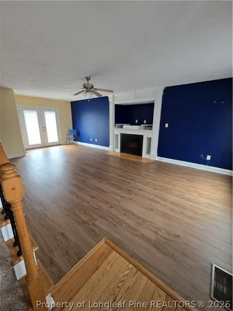 a view of a livingroom with wooden floor and staircase