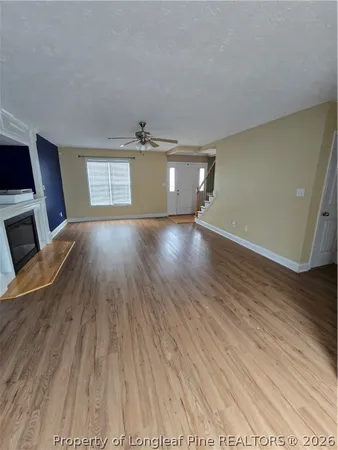 an empty room with a window and a fan