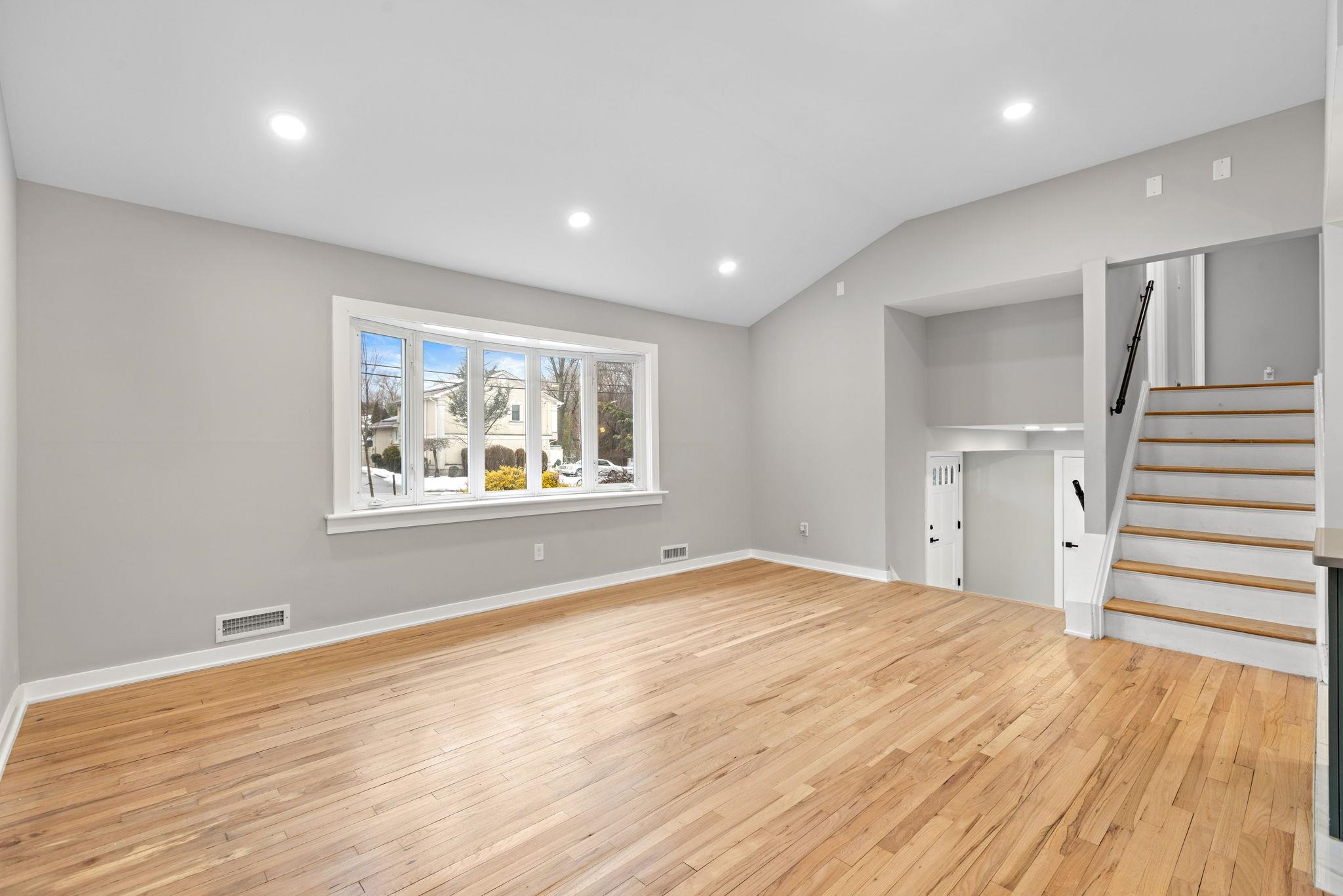 125 Rutgers Place Clifton, NJ 07013 - Photo 7 of 36 a view of an empty room with wooden floor and a window