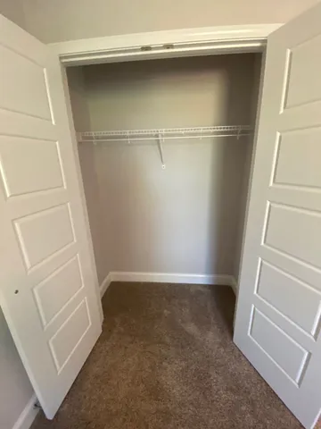 a view of an empty room with a chandelier fan
