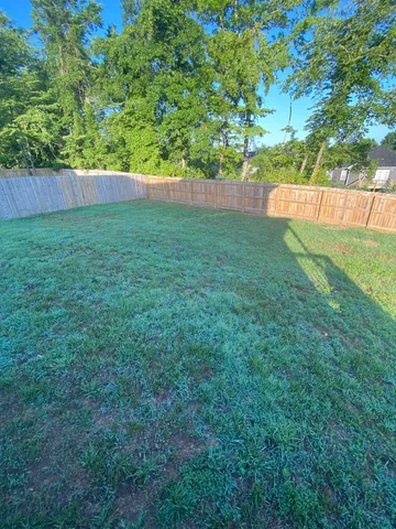 a balcony with wooden floor and yard in the back