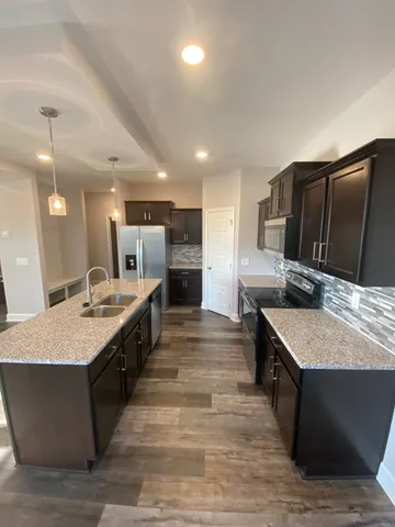 a large kitchen with kitchen island a sink counter space and stainless steel appliances
