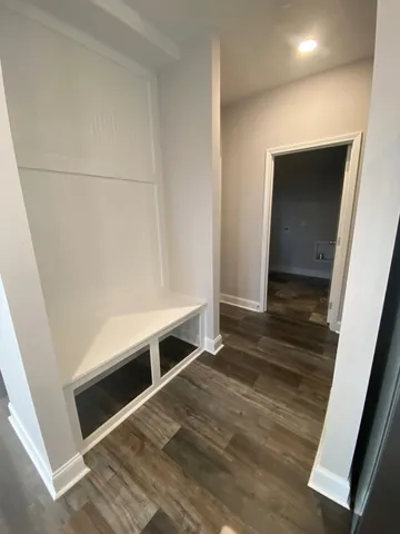 a view of an empty room with wooden floor and closet