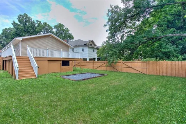 a view of a house with a yard and a fence