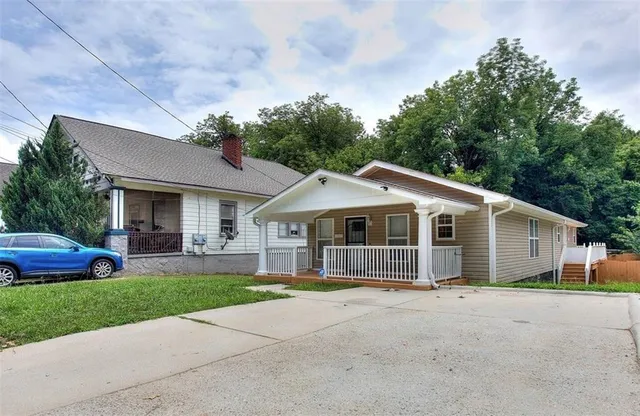 a front view of a house with a garden and trees