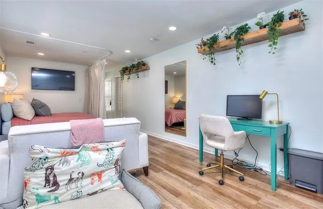 a living room with furniture and a wooden floor