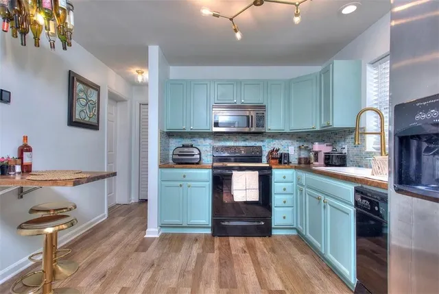 a kitchen with kitchen island granite countertop a sink cabinets and stainless steel appliances