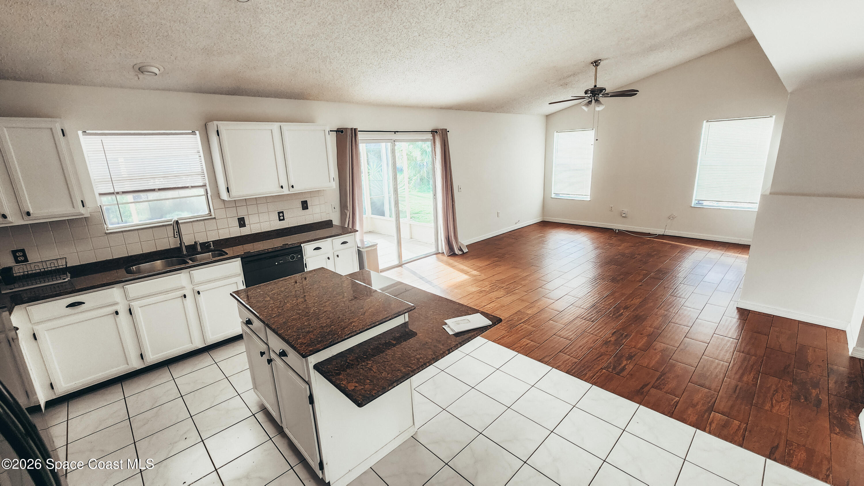 1521 Barber Street Sebastian, FL 32958 - Photo 12 of 33 a open kitchen with stainless steel appliances granite countertop a stove a sink and white cabinets with wooden floor
