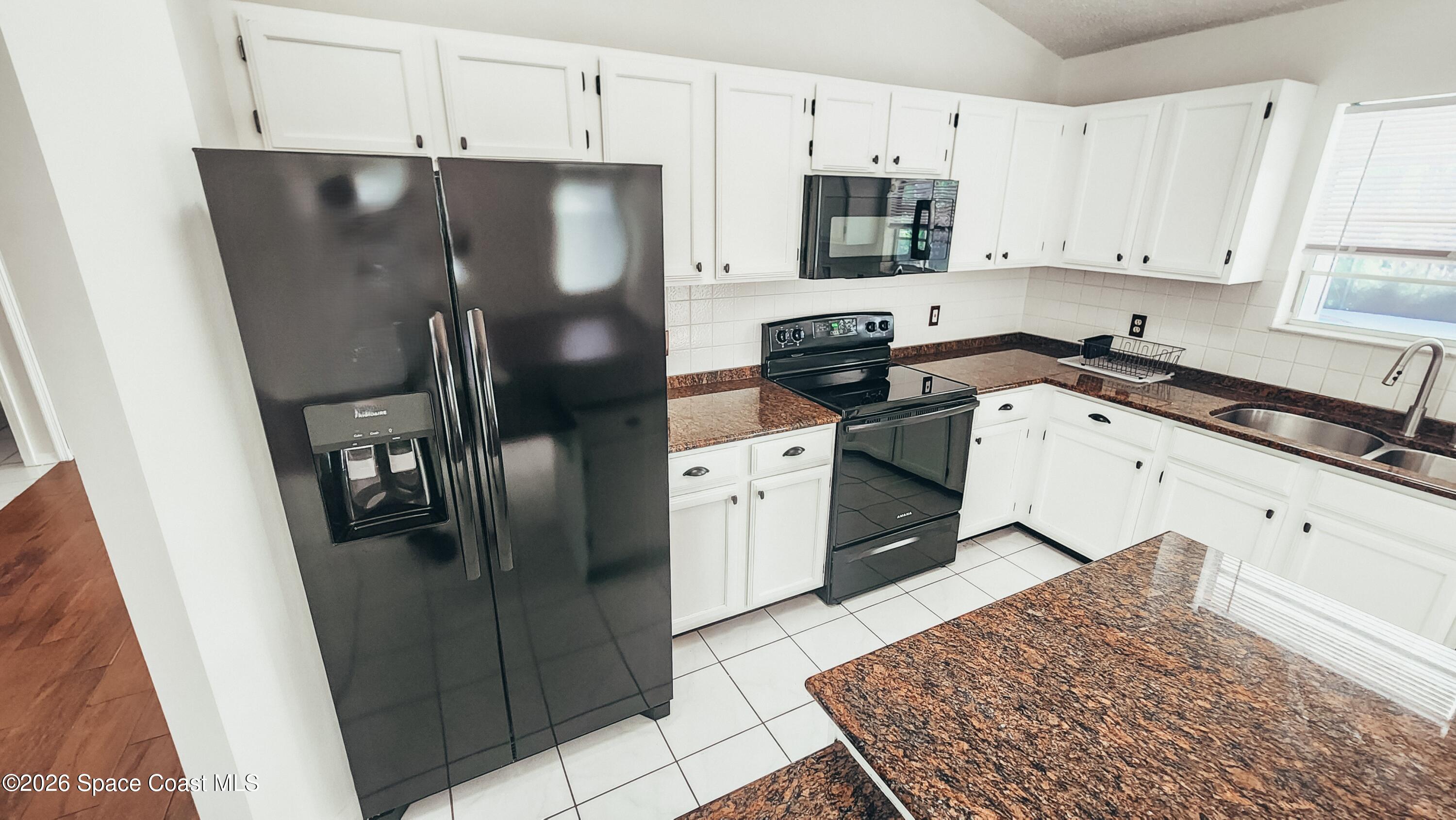 1521 Barber Street Sebastian, FL 32958 - Photo 13 of 33 a kitchen with stainless steel appliances granite countertop a refrigerator stove and sink