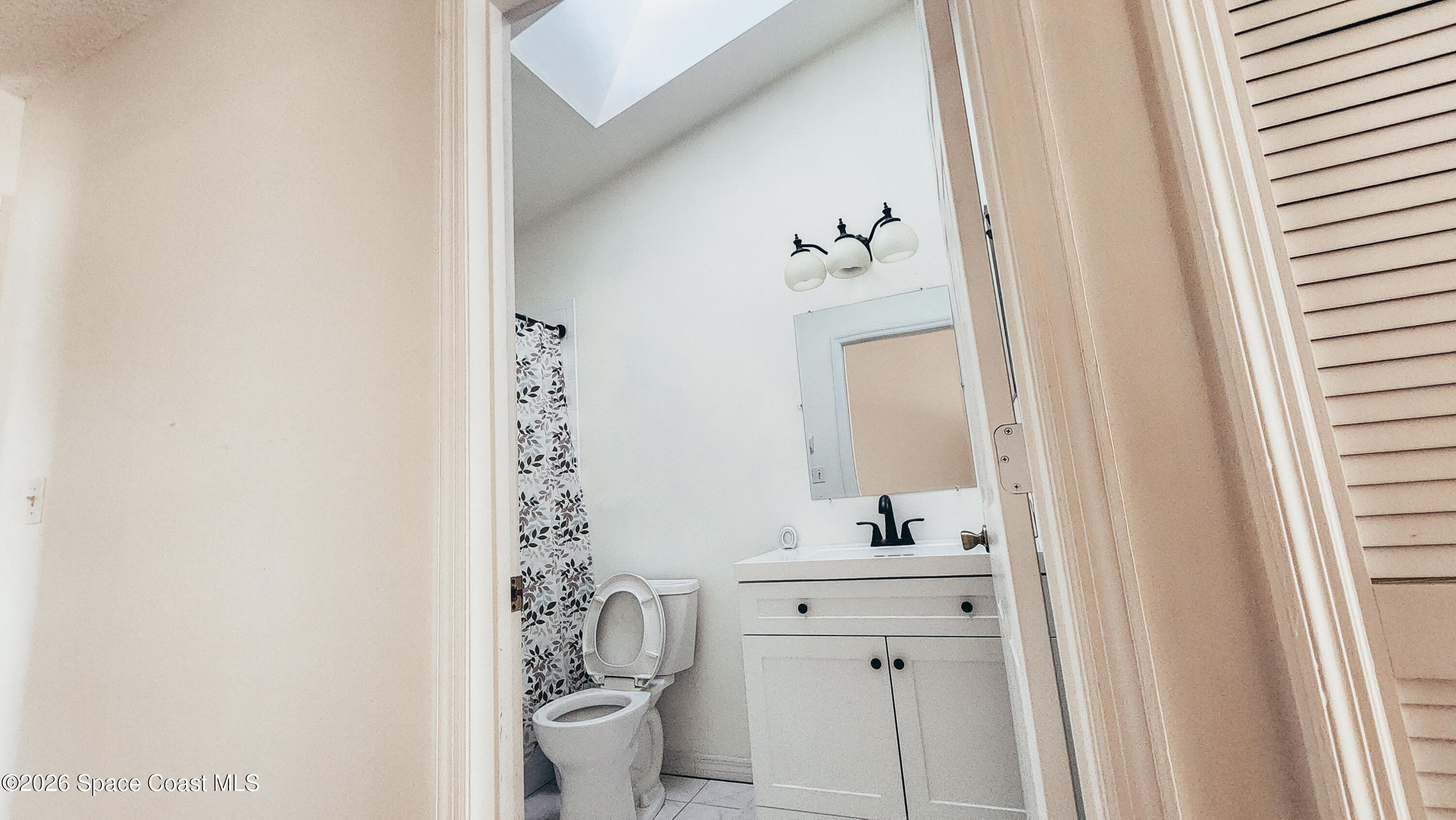 1521 Barber Street Sebastian, FL 32958 - Photo 17 of 33 a bathroom with a sink a toilet and shower curtain