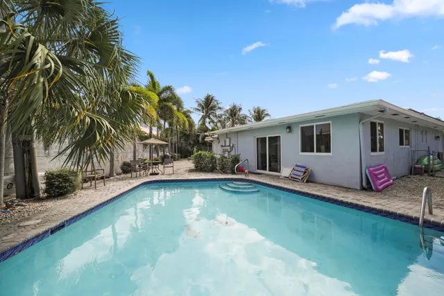 a view of a house with swimming pool and a yard