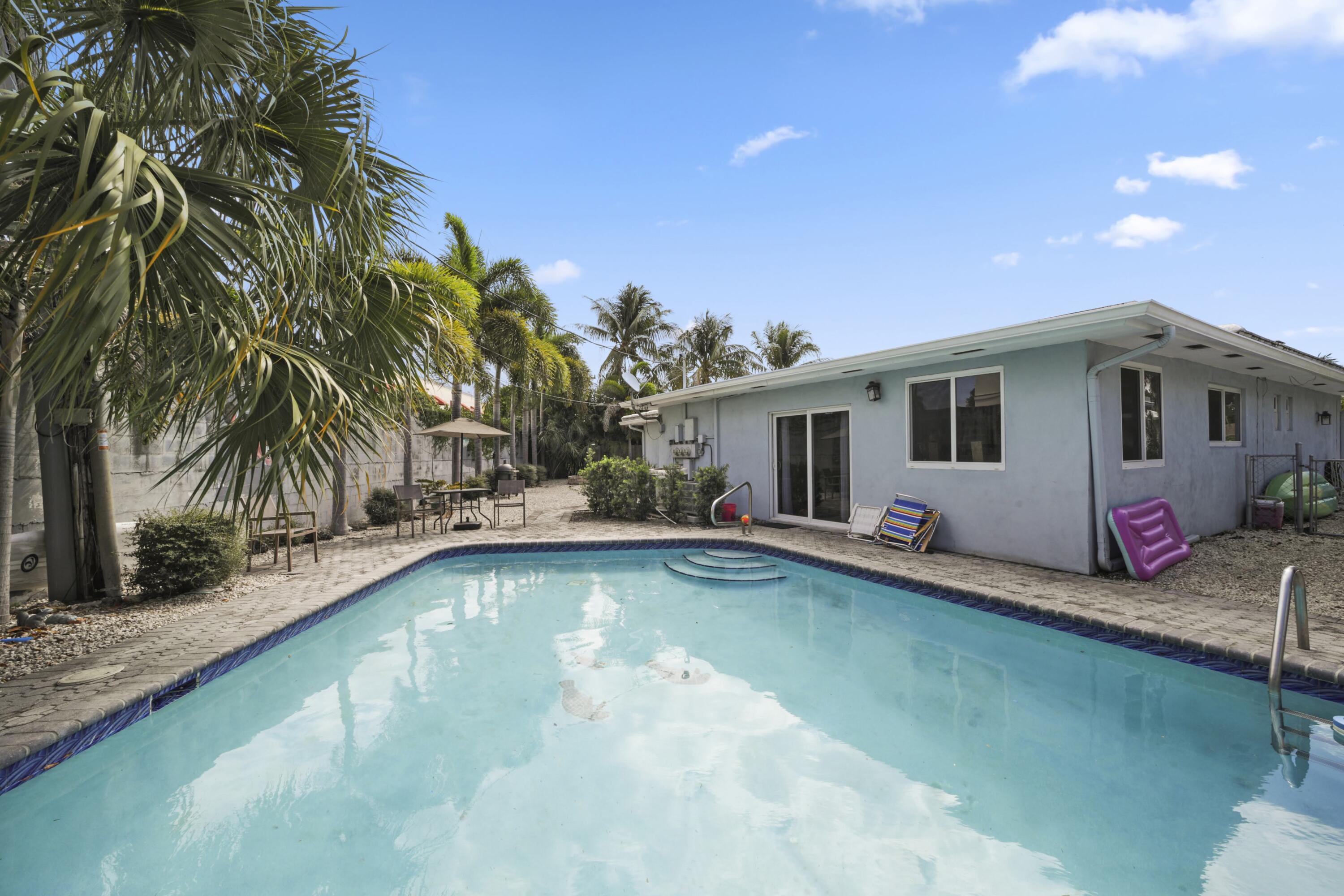 a view of a house with swimming pool and a yard
