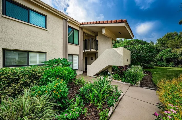 a view of a house with a small pool and potted plants