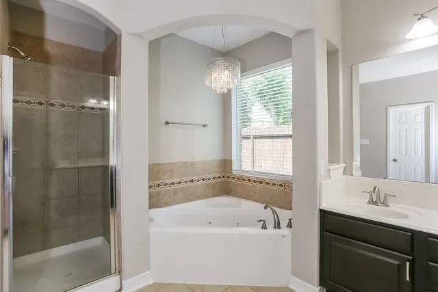 a bathroom with a tub a sink and windows