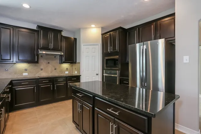 a kitchen with granite countertop stainless steel appliances and wooden cabinets