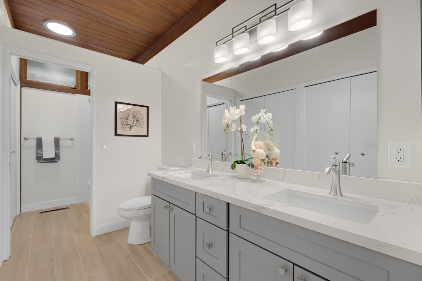 21221 Canyon View Drive Saratoga, CA 95070 - Photo 28 of 45 a bathroom with a granite countertop sink a toilet and a mirror
