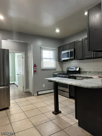 a kitchen with stainless steel appliances granite countertop a sink and a refrigerator
