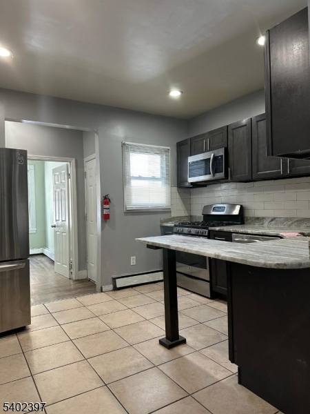 8 4th Street Passaic, NJ 07055 - Photo 2 of 10 a kitchen with stainless steel appliances granite countertop a sink and a refrigerator
