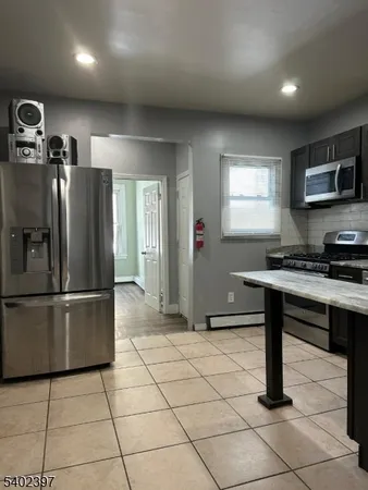 a kitchen with kitchen island a counter appliances a sink and a window