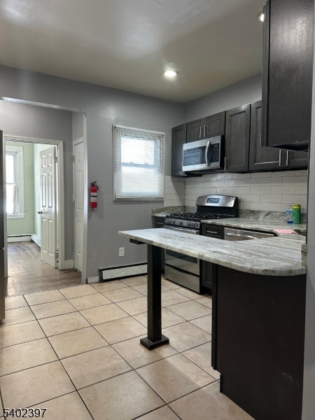 8 4th Street Passaic, NJ 07055 - Photo 5 of 10 a kitchen with a sink cabinets and window