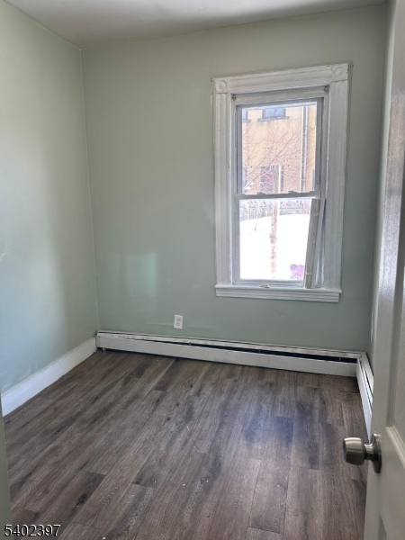 8 4th Street Passaic, NJ 07055 - Photo 7 of 10 an empty room with wooden floor and windows