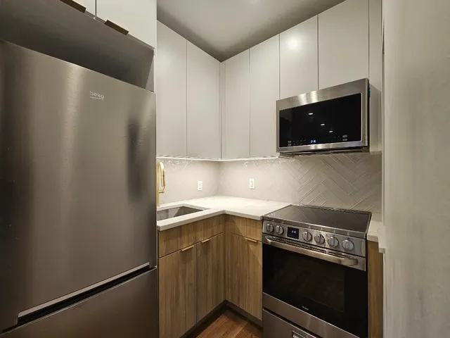 a stove top oven sitting inside of a kitchen