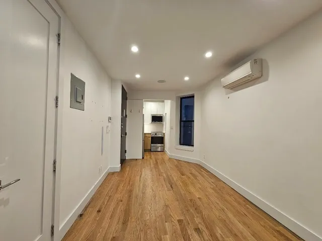a view of a big room with wooden floor and windows