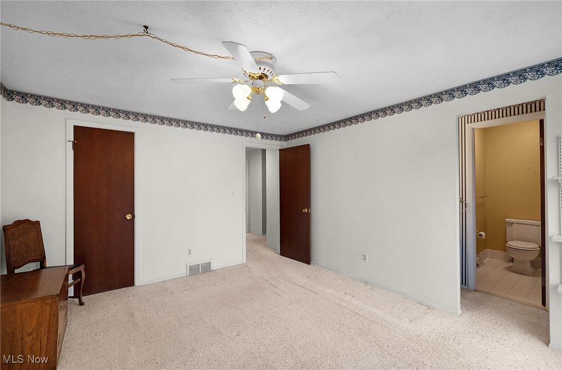 6474 State Road, Unit I10 Parma, OH 44134 - Photo 17 of 31 Unfurnished bedroom featuring carpet flooring, ceiling fan, ensuite bathroom, and a textured ceiling