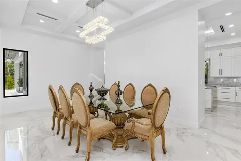 a large white kitchen with a large counter top stainless steel appliances and cabinets
