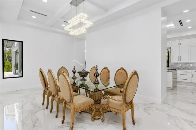 a large white kitchen with a large counter top stainless steel appliances and cabinets