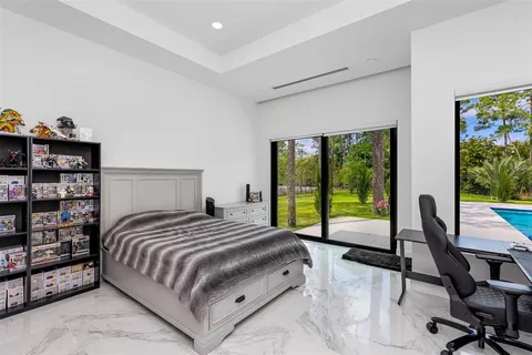 a bedroom with a bed a dresser and next to a window