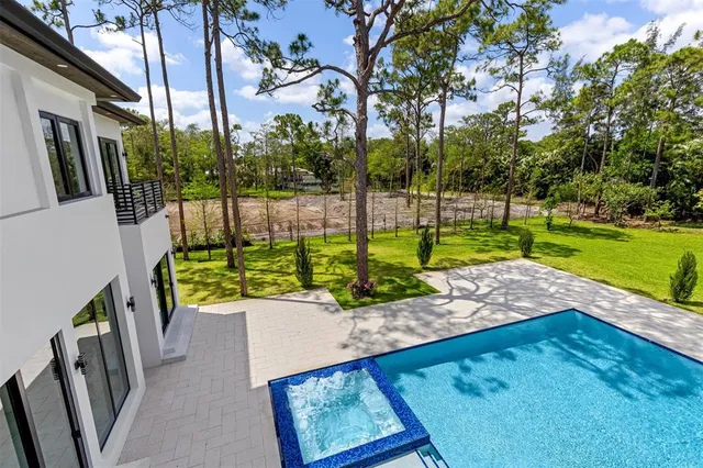 a view of a swimming pool with a yard and sitting area