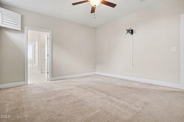 a view of an empty room with a chandelier fan