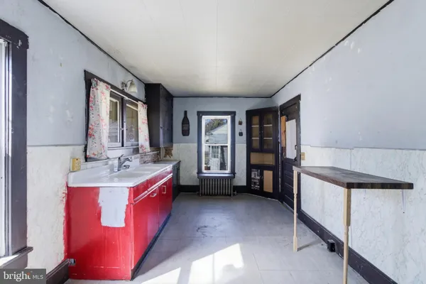 a view of an empty room with window and cabinet