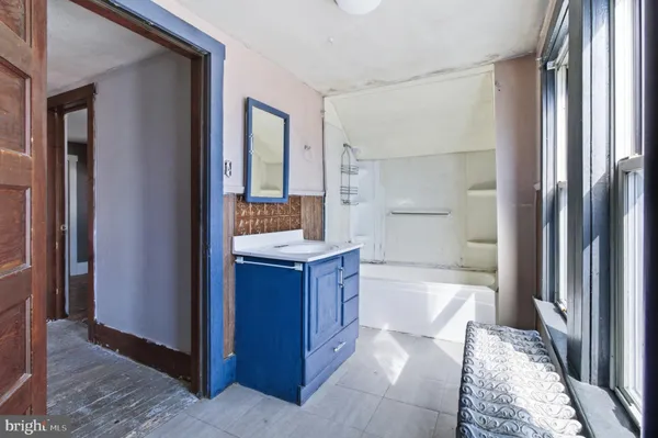 a bathroom with a bathtub shower sink and mirror